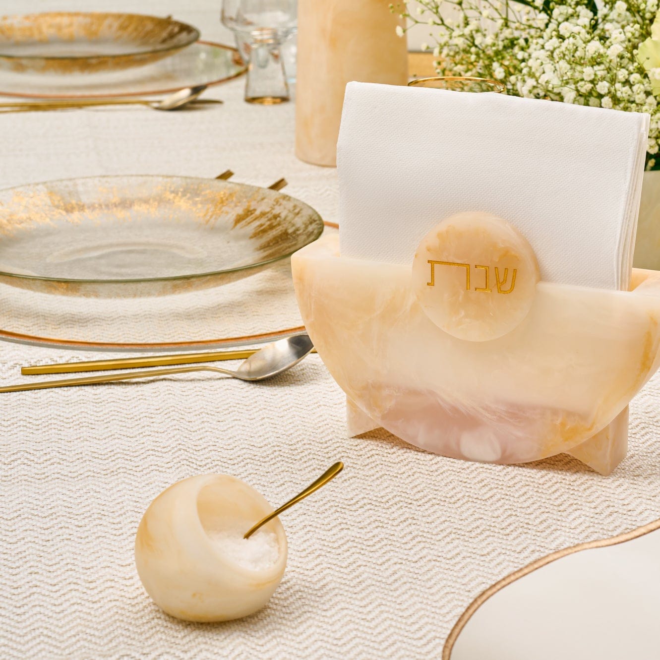 Beige marble-style resin salt cellar with spoon styled on an elegant Shabbat table setting – Waterdale Collection