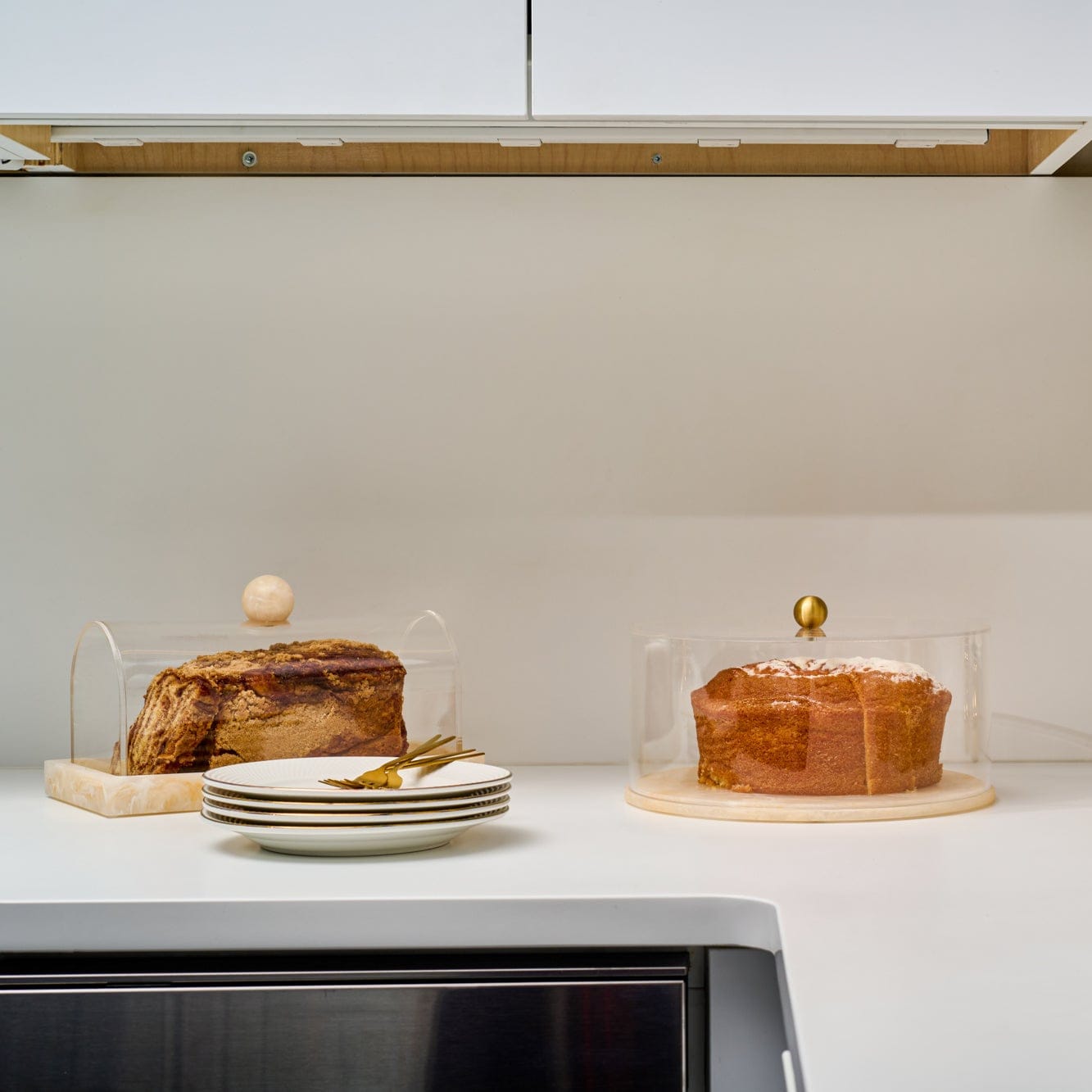 Small rectangular resin cake dome by Waterdale Collection displayed with a layered cake, featuring a warm amber tone and elegant design for serving and storage.
