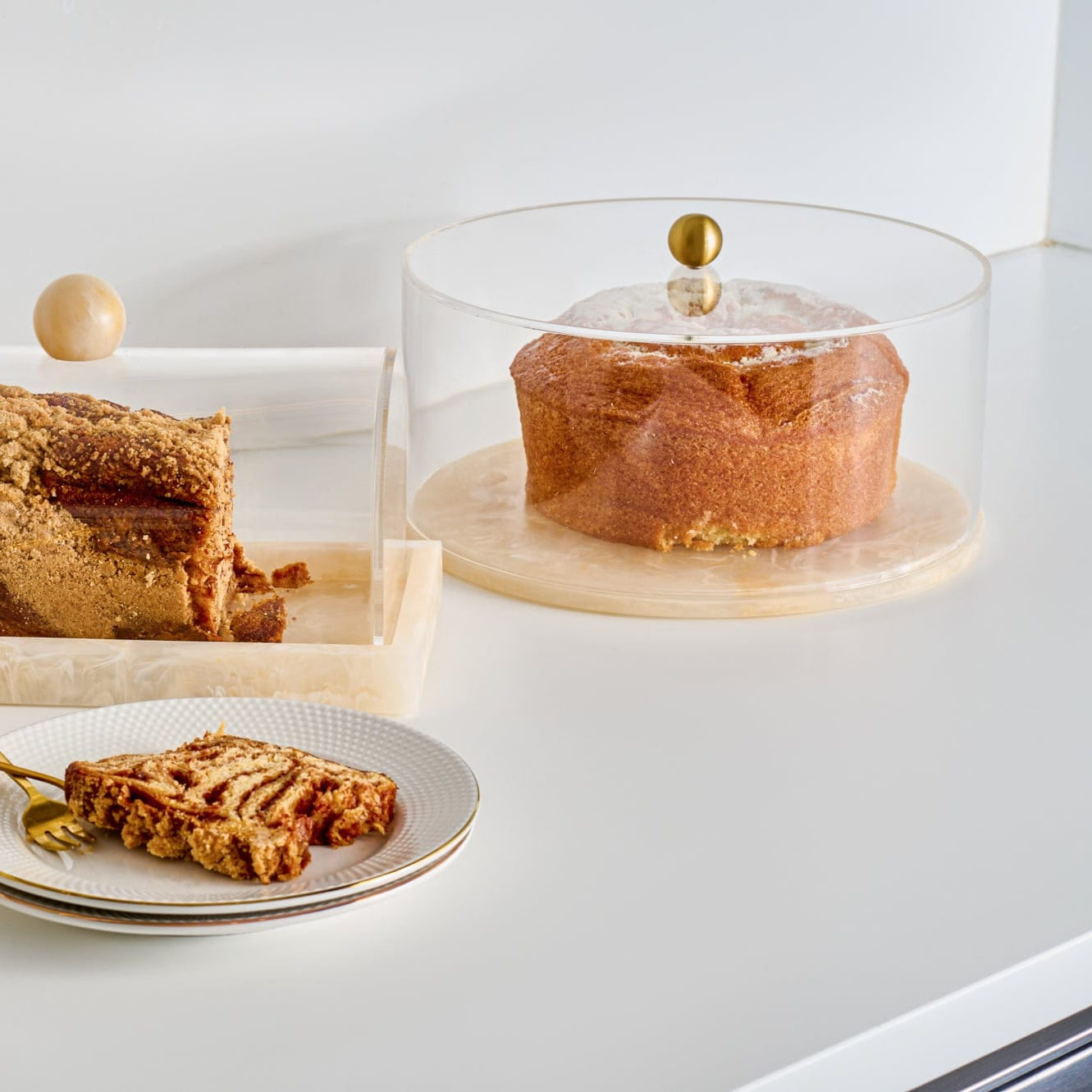 Round Resin Cake Dome featuring a clear acrylic cover with a sleek gold knob and a coordinating marbled cream resin base, designed to elegantly display and protect cakes and pastries for Shabbos, Yom Tov.