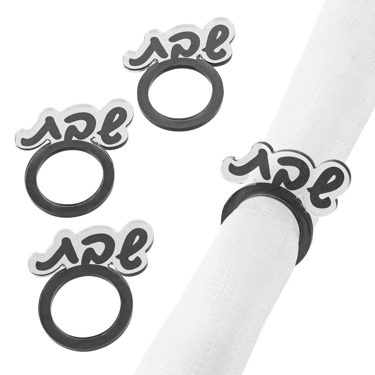 Four silver Shabbos napkin rings with Hebrew lettering arranged on white fabric, perfect for Shabbat table settings.