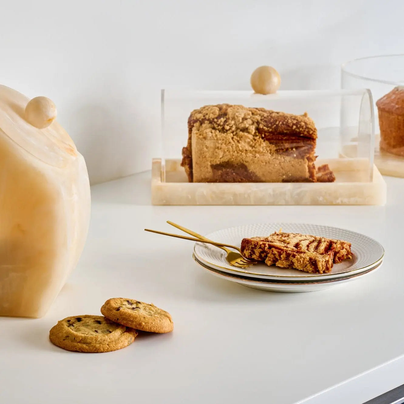 Small rectangular resin cake dome displaying cake on a styled dessert table with marble surface and gold utensils – Waterdale Collection