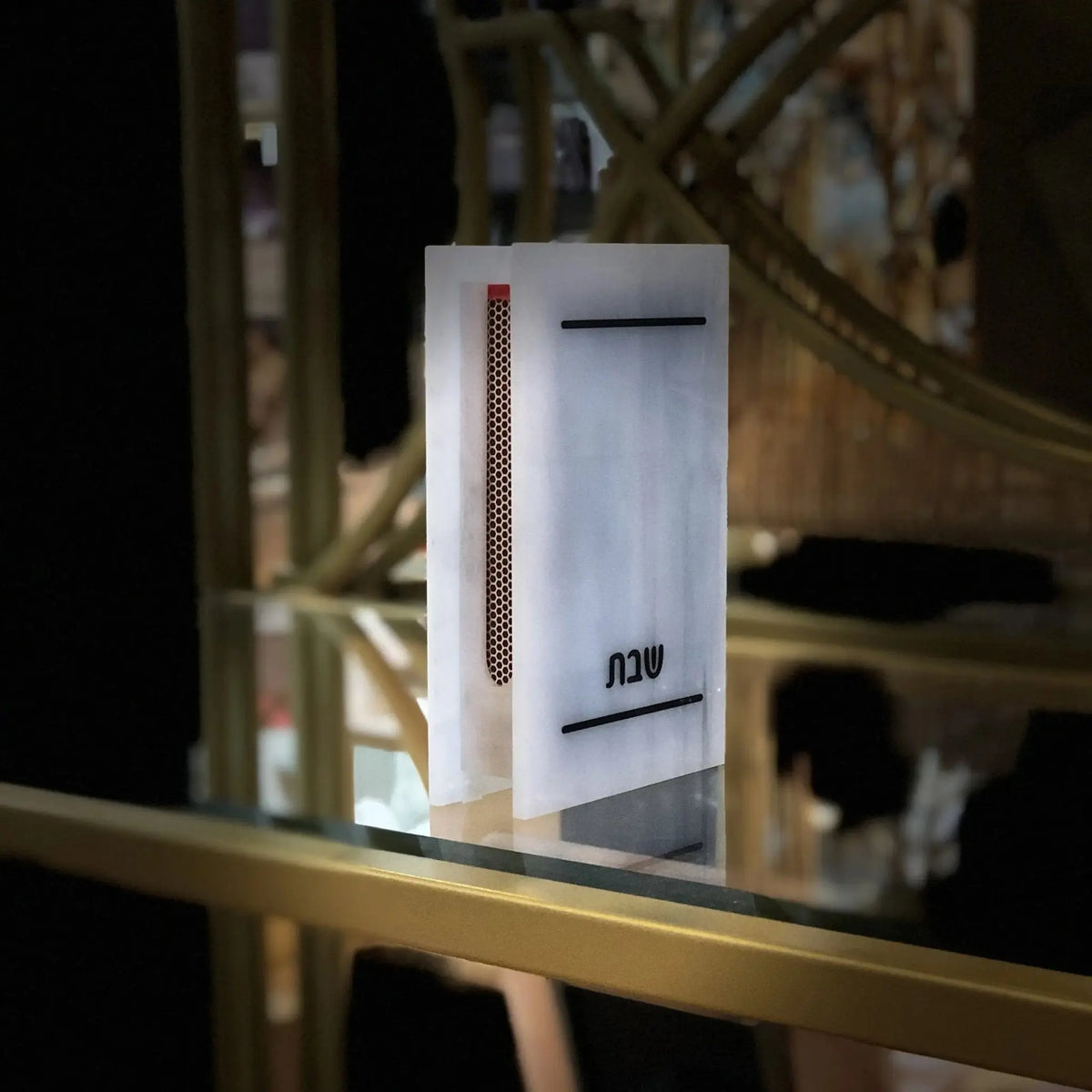 Traditional marble matchbox holder with silver shimmer finish, displayed on a shelf with home decor items in background