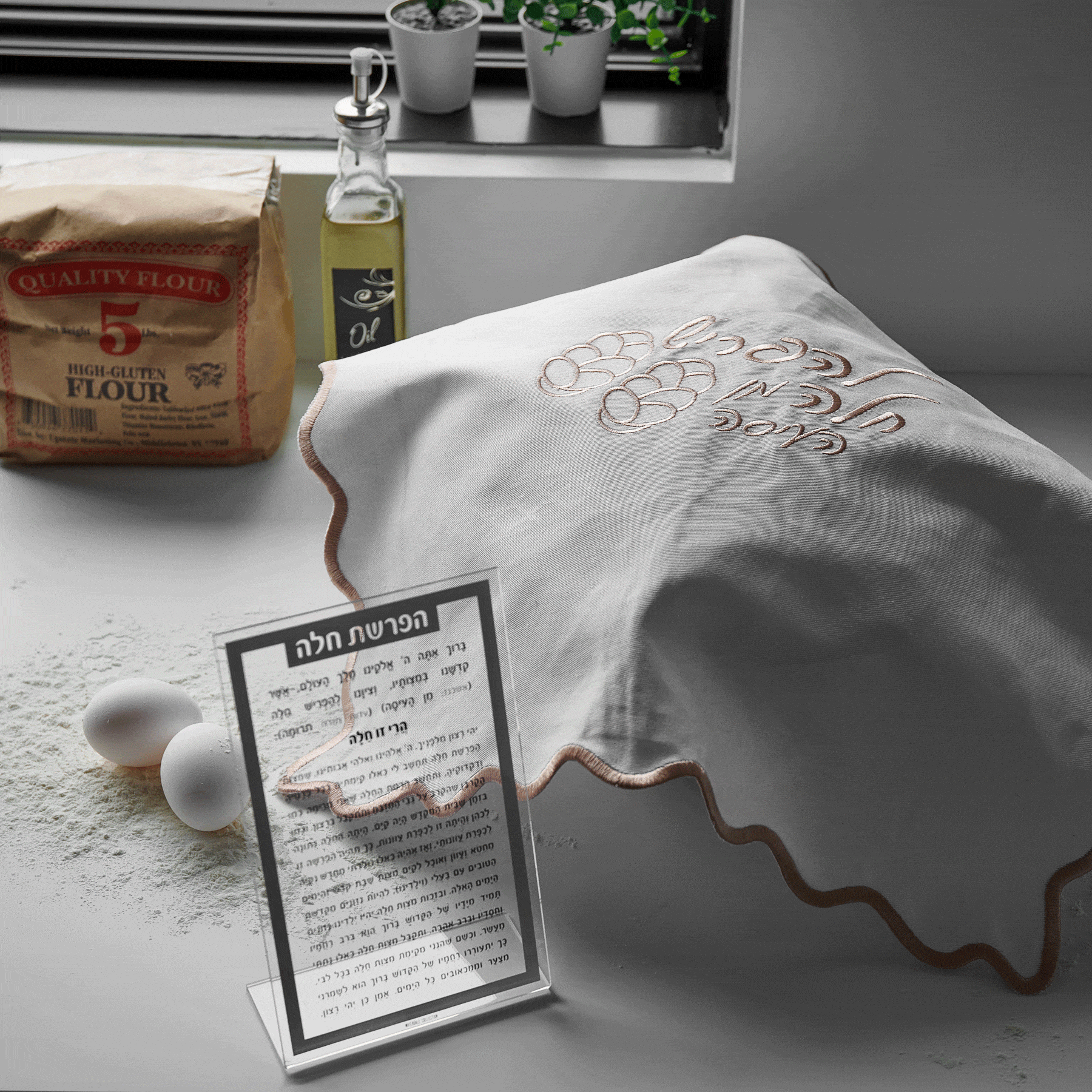 Wavy silver leather challah cover by Waterdale Collection displayed on white surface with product card and items nearby