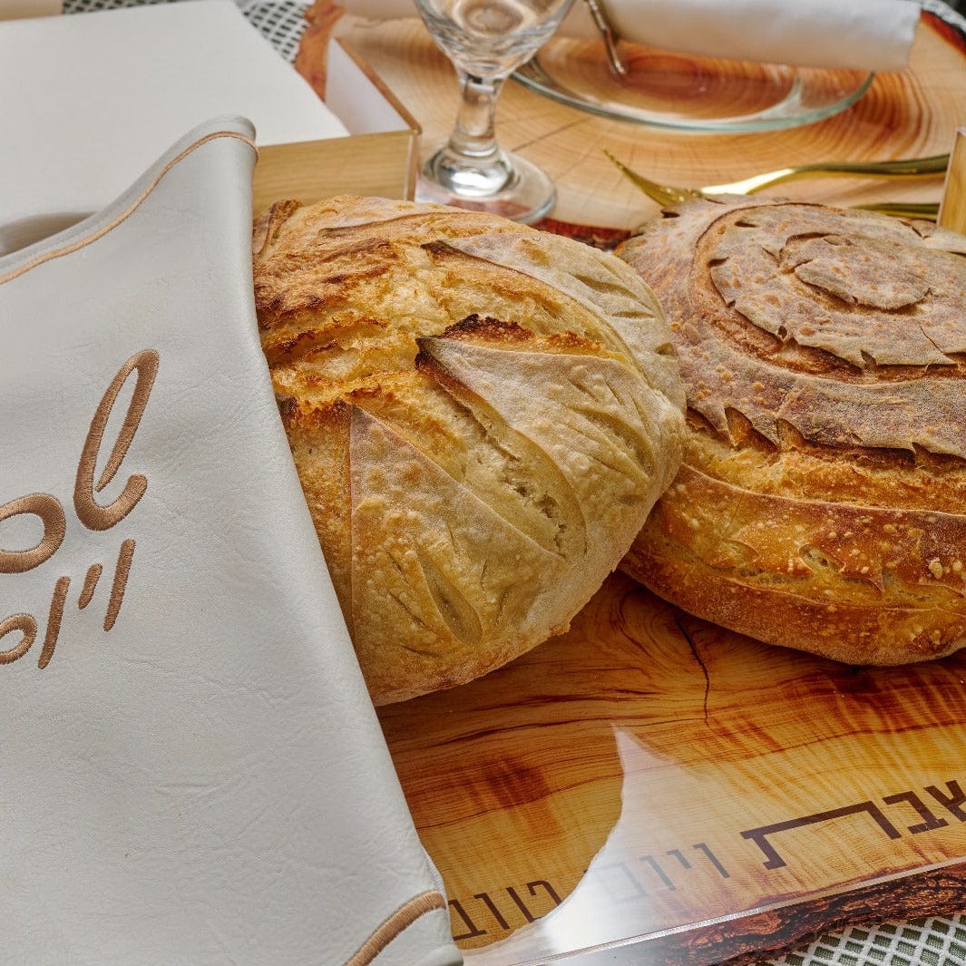 Wooden Challah Board with two freshly baked challah loaves.
