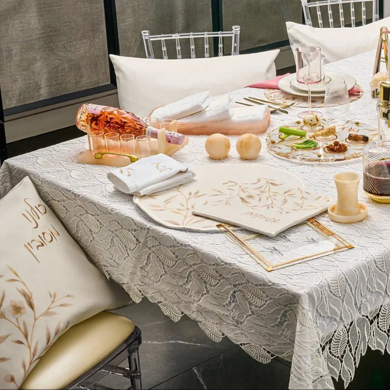 Floral Bird Pesach Set in gold and white leather displayed on table with place settings and holiday tableware