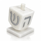Silver resin dreidel sculpture match jar for Hanukkah (חנוכה), a sculptural match holder beside the menorah