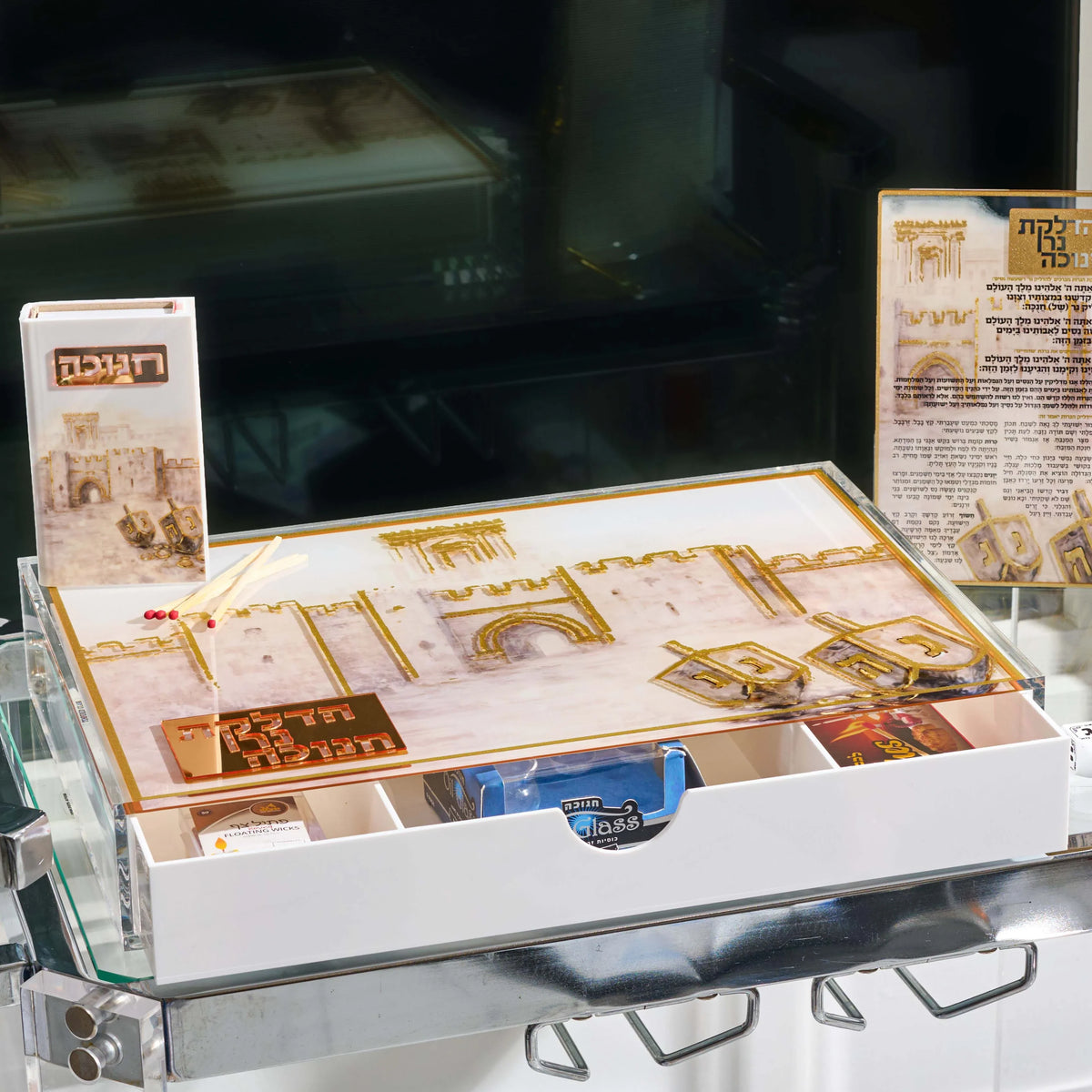 Hanukkah menorah tray with the drawer open to candles, matches, and wicks, beside the painted Jerusalem match box and brachos tabletop