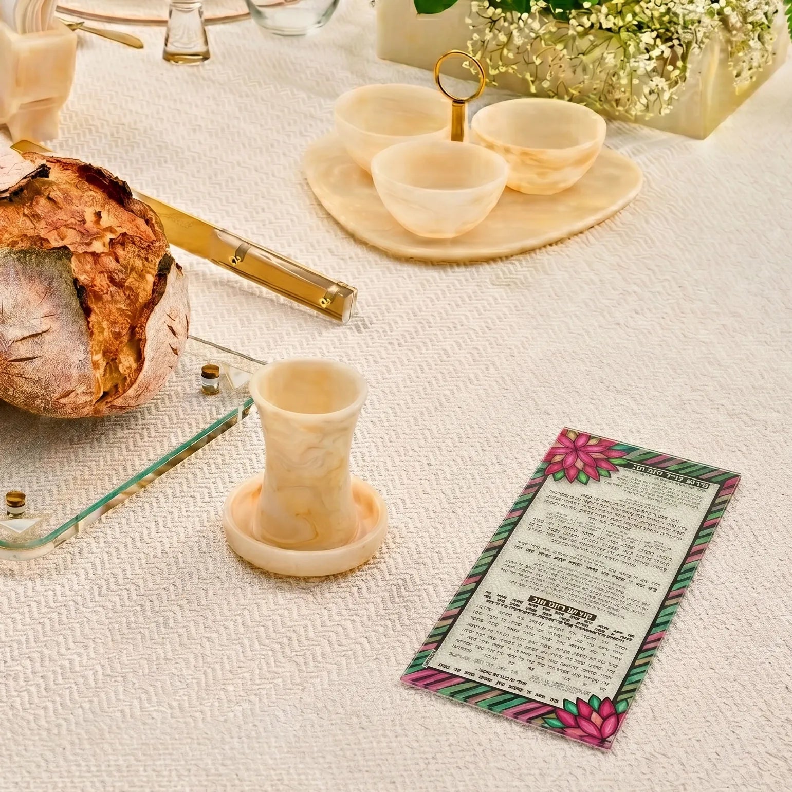 Table setting with bread, candle, and colorful color it acrylic card on a white tablecloth - Waterdale Collection