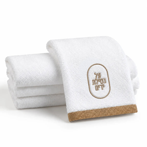 Stack of white Al Netilat Yadayim hand towels with taupe oval embroidery and taupe trim, folded for the washing station