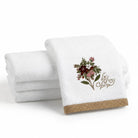 White cotton netilas yadayim finger towels folded in a stack, showing the floral embroidery and על נטילת ידים in tan script