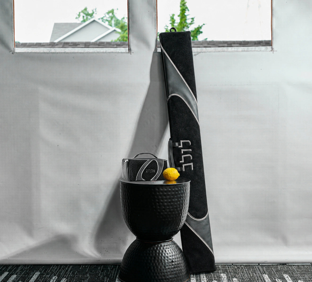 A lifestyle image of a coordinating black and gray faux leather lulav and esrog case for Succos