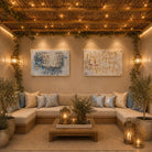 Painted Kosel by Yosefa vinyl sukkah decorations in blue and gold hung side by side above a sectional sofa in a candlelit sukkah
