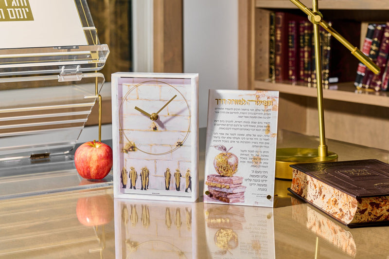 Modern Jewish home decor featuring a marble-style desk clock with gold accents and a Hebrew prayer plaque, styled with books, acrylic stand, and warm-toned workspace accessories. | Waterdale Collection