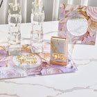 Waterdale Collection papercut Hadlakas Neiros tabletop display with gold-foil Jewish prayer art on marble surface, styled with candles and flowers.