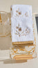 Floral design towel set up in floral towel tray and washing cup, soft plush texture of towel shown
