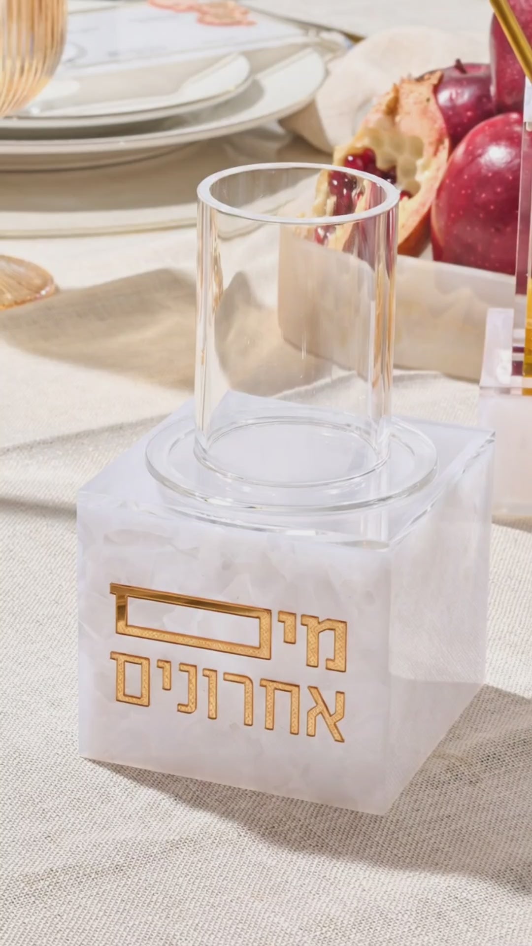 Pearl mable designed mayim acharonim in use, pouring water from cup on to hands