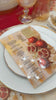 Rosh Hashana Table setting featuring painted designed leather charger, leather napkin wrap, lucite simanim card. tutorial showing how to make the setting.