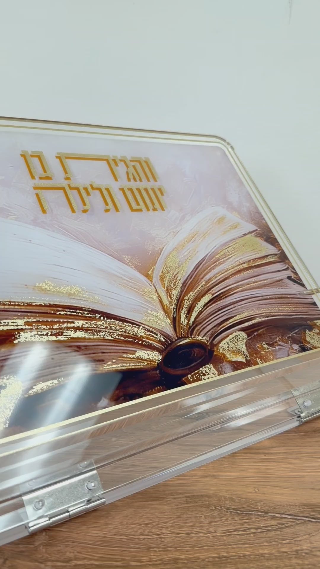 Foldable lucite tabletop Shtender with painted sefer design, featuring the words Vehagisa Bo Yomam V'layla. Soft gold accents on top. Video showing the foldable mechanism and putting a sefer on the shtender.