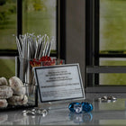 Waterdale Collection Chanukah candle holder with striped design and blue glass accent, displayed on desk with informational card