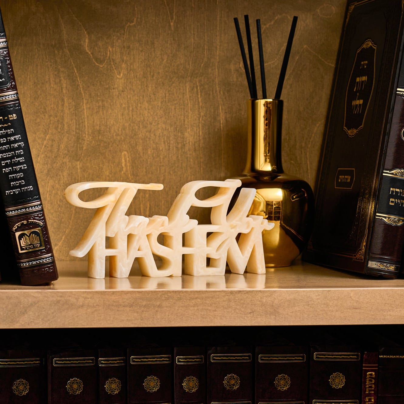 Gold Resin Thank you Hashem sculpture set on a bookshelf with Diffuser and Sefarim.