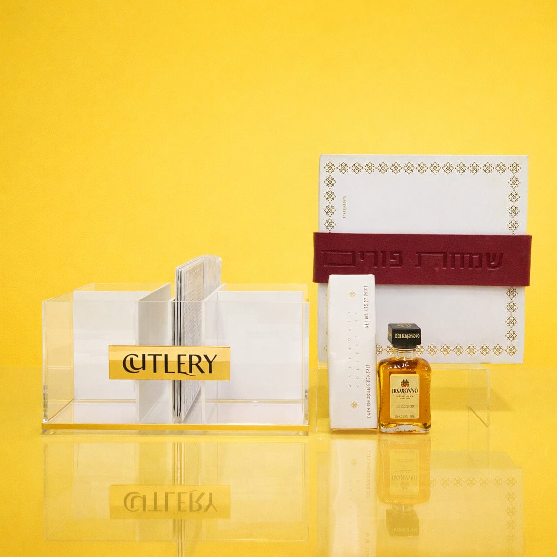 Bencher set silverware caddy with clear acrylic cutlery holder and elegant bencher display, styled as a Mishloach Manos gift against a yellow background.