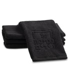 Black embossed finger towel from Waterdale Collection for netilas yadayim hand washing, folded stack display.