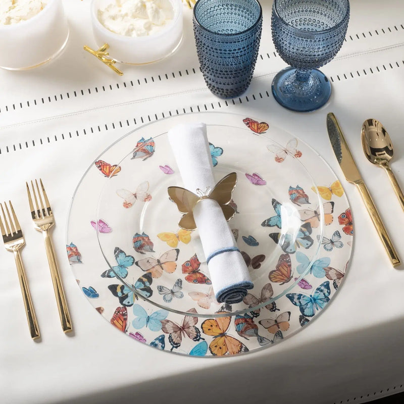 Waterdale butterfly chargers featuring colorful illustrated butterflies and florals on white ceramic plates, displayed with place settings and blue glassware.