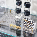 Onyx Butterfly Hadlokas Neiros Set with black and white checkered candlestick holders and matching square bases displayed on glass shelf.