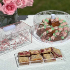 Cherry Blossom Acrylic Cake dome in circle and rectangle shape. Soft pink cherry blossom design on crystal clear acrylic. Set on an outdoor summer scene filled with cake.