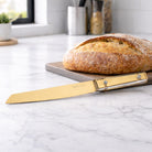 Luxury gold bread knife and fresh artisan bread in a bright, modern kitchen setting - waterdale collection