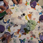 Children crafting at a butterfly-themed table doing Color it Acrylic Mosaic Modeh Ani.