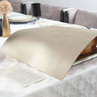 Embossed Regal Challah Board with cream-colored cover set displayed on white bedding with home decor in background