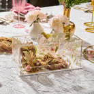 Floral Bird Cake Dome, clear acrylic cake holder with pink floral design and gold bird handle, elegant Shabbos dessert display, luxury Judaica table decor, modern Pesach serving piece for cakes and pastries.