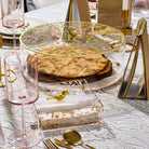 Floral Bird matzah box in clear acrylic with gold bird detail and floral design, displayed on an elegant Pesach Seder table.