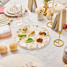 Modern round lucite Seder plate featuring an artistic floral vine pattern, gold-rimmed edges.