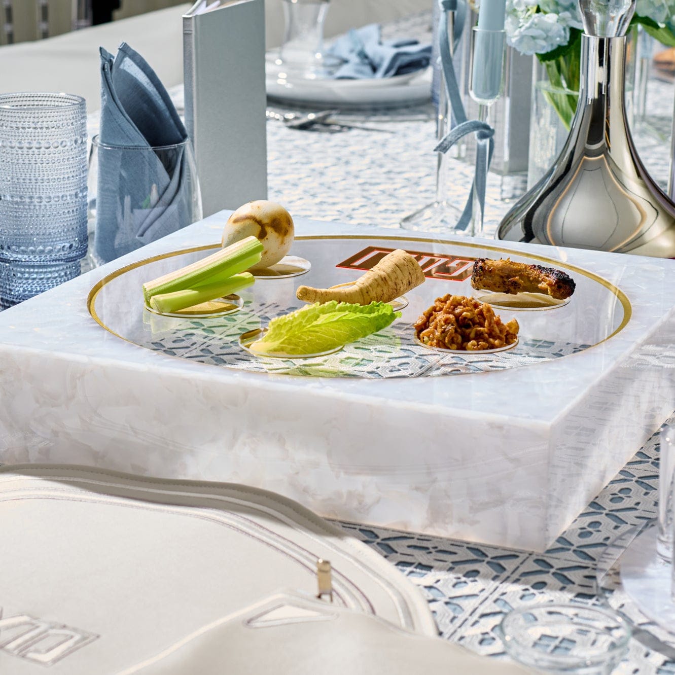 Frame Seder Plate in white marble acrylic with gold rim, modern Passover Pesach plate with Hebrew labels and traditional Seder foods, luxury Judaica holiday table centerpiece.