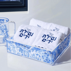 Blue and white decorative towel set with Hebrew text displayed in matching porcelain holder and pitcher