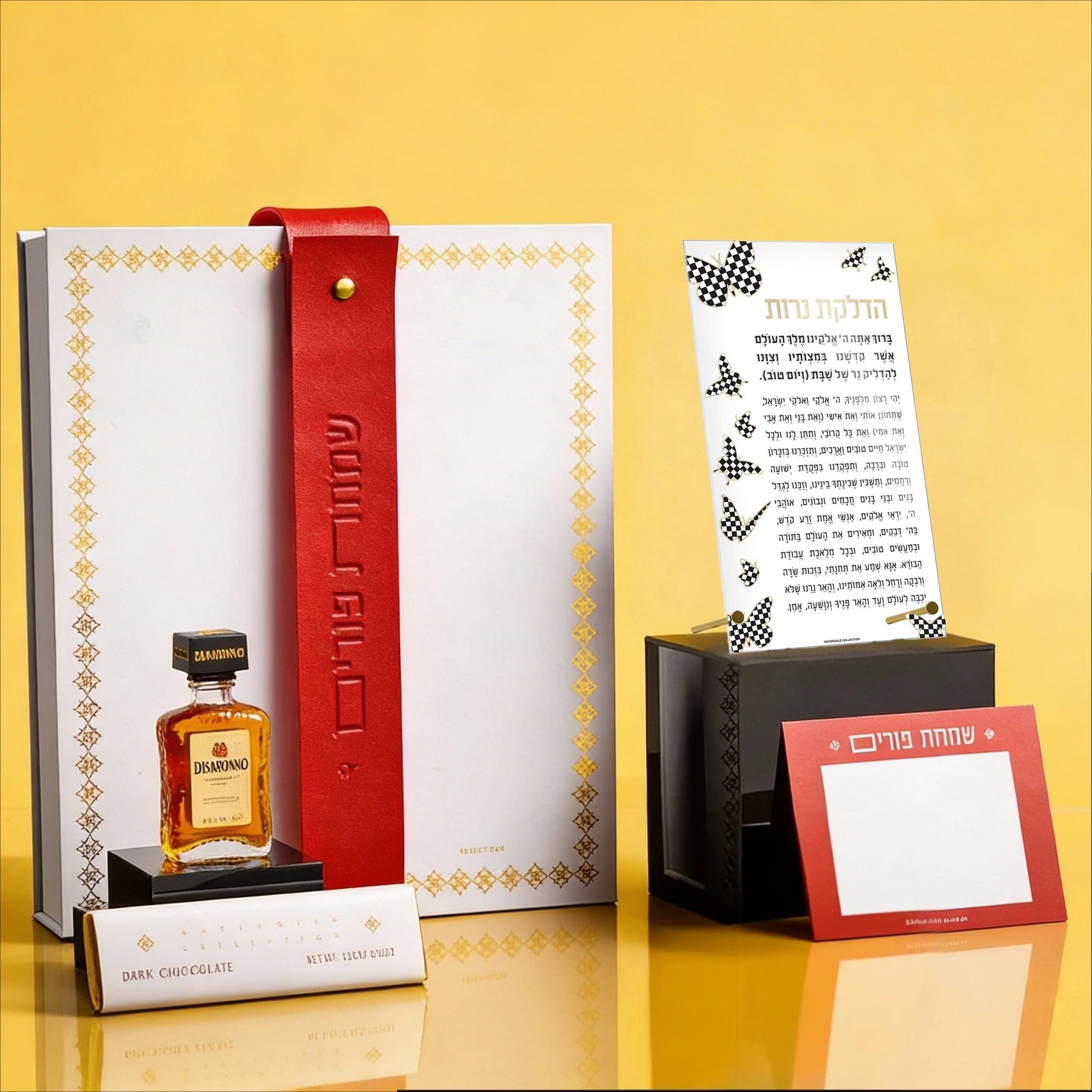 Luxury Mishloach Manot gift box featuring a Onyx Butterfly Hadlokas Neiros in a lucite stand, a white leatherette pouch with a red strap, and a mini Disaronno liqueur.