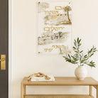 Hand-Painted  Im Eshkachech displayed above a wooden console table with a vase and a decorative bead garland.