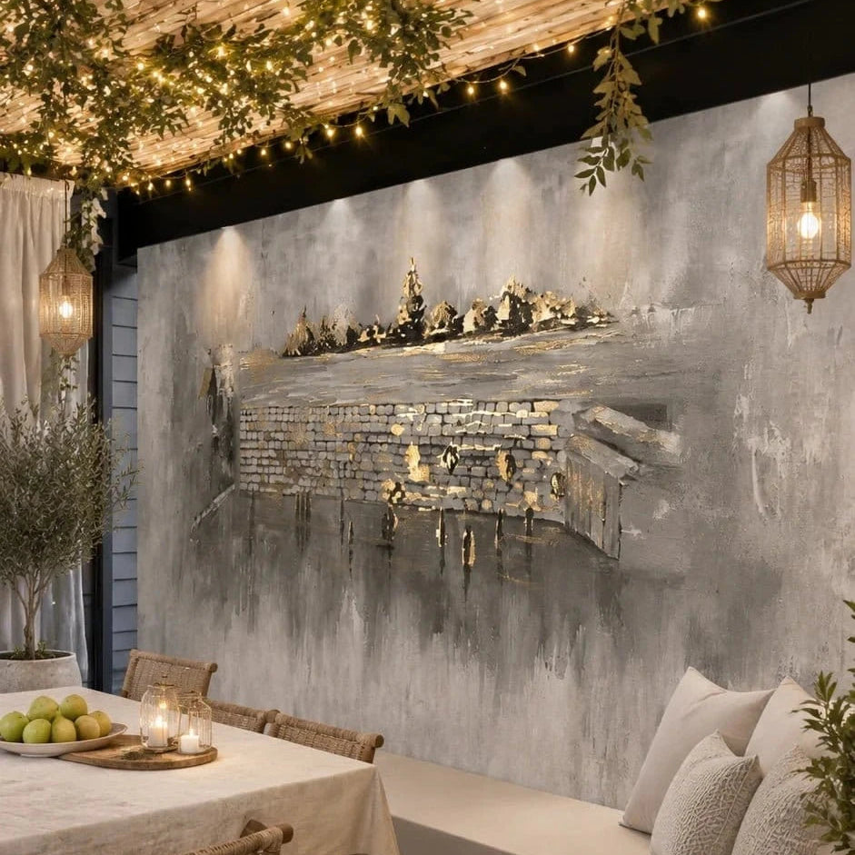 Kosel After Rain vinyl sukkah mural on a full sukkah wall above a linen daybed, lit by string lights and candle lanterns
