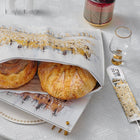 Kosel at Winter painted challah set featuring two golden braided loaves on white ceramic platter with artistic landscape design, displayed with gold accessories.
