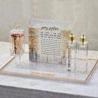 Kosel Hadlokas Neiros candle lighting set with clear acrylic organizer, gold-toned accessories, and informational card on marble base.