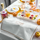 Leaf Challah Cover on a festive holiday table with gold tableware, honey, pomegranate seeds, and symbolic foods for Rosh Hashanah.