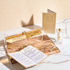 Leather Booklet Chanukah Set by Waterdale Collection featuring tan leather case with prayer book, candles, and gold accessories on marble surface
