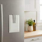 White leather kitchen card magnet set holding three printed prayer cards on a stainless steel refrigerator, shown in a bright kitchen setting -  Waterdale Collection