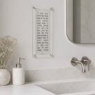 Marble finish in middle of a lucite sign featuring Asher Yatzar in the middle with silver screws hanging over a sink.