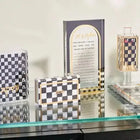 Onyx Hadlokas Neiros set with checkered pattern candle holders and prayer cards on glass display shelf