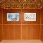 Painted Kosel by Yosefa Vinyl Sukkah Decoration displayed on wood-paneled sukkah walls under schach roofing.