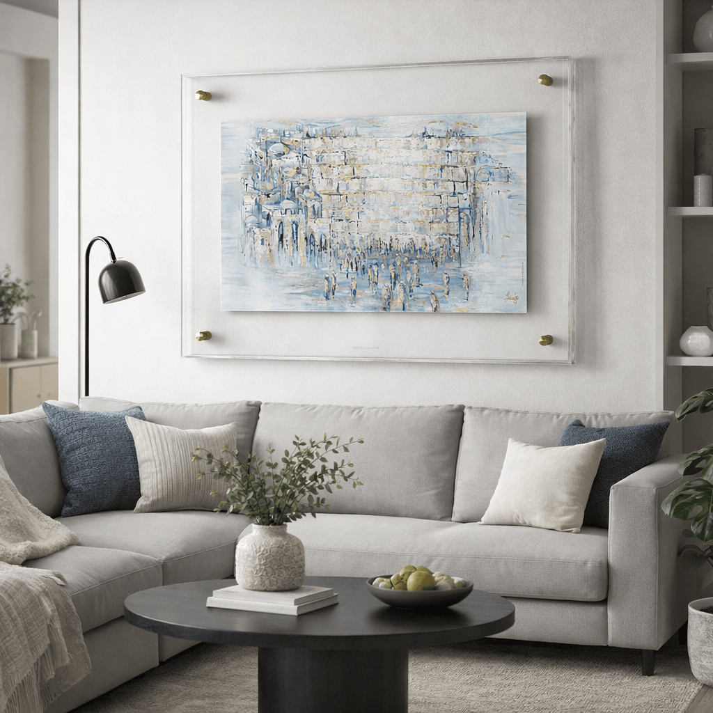 Painted Yosefa Pearlstone Kosel artwork displayed in a clear acrylic frame, featuring the Western Wall in soft blue and neutral tones.