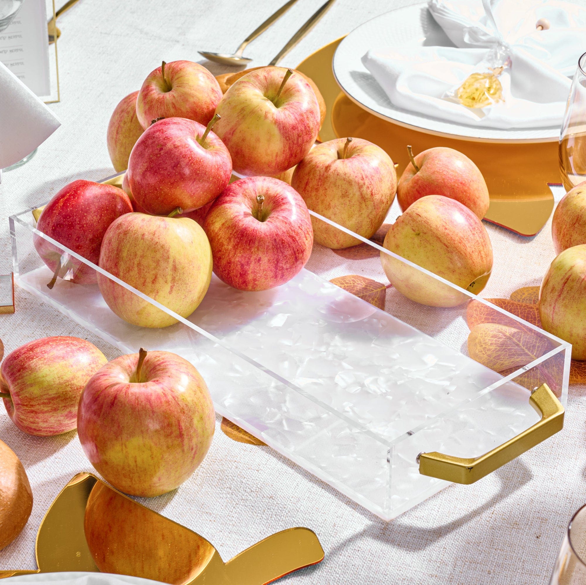 Fresh apples are displayed in a Pearlstone Bread / Towel Tray on an elegant table setting.